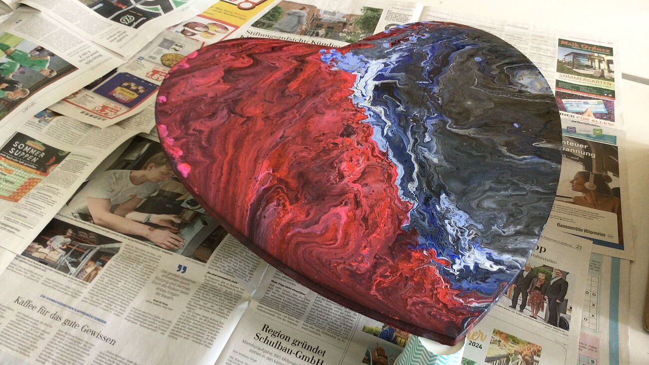 Ein gebasteltes Herz, das links rot und rechts blau ist