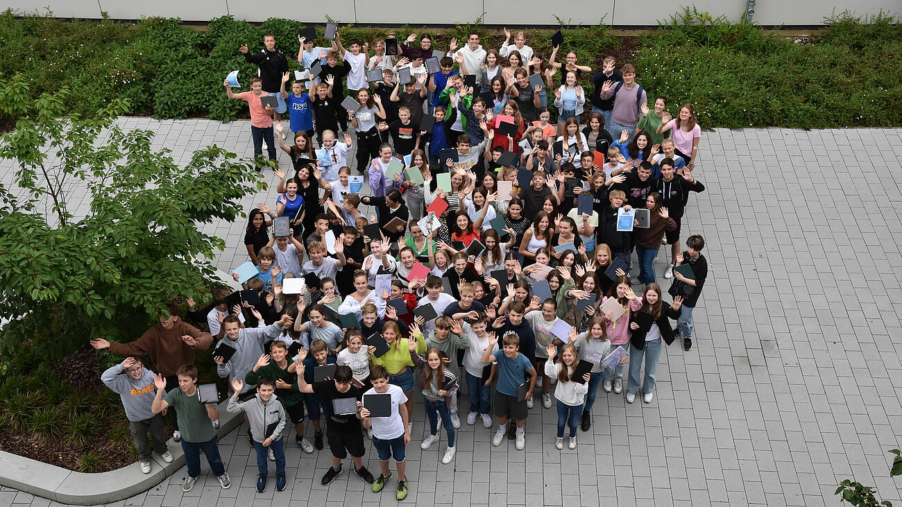 Foto von Schülerinnen und Schülern mit Tablets