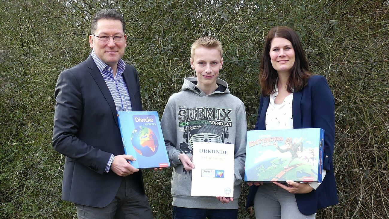 Schulleiter Robert Baberske und Erdkunde-Lehrerin Johanna Lameyer gratulieren Sven-Ole Gülke zu seinem Erfolg.